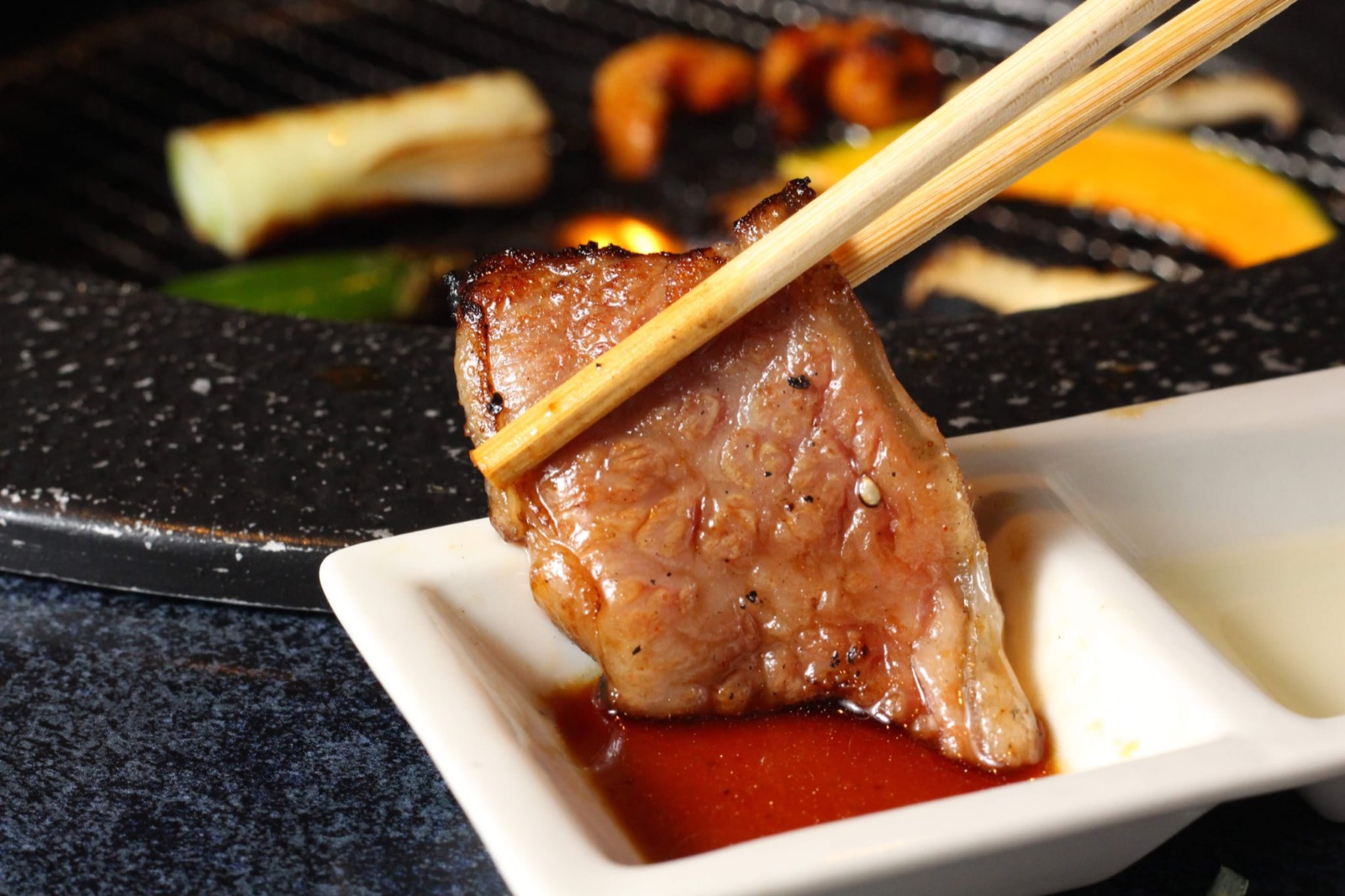 焼いた肉を自家製のタレへ